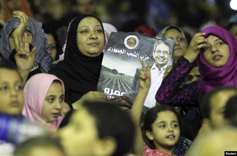 Supporters of presidential candidate and former Arab League secretary general Amr Moussa hold posters during a campaign rally in El-Kalubia, May 16, 2012.