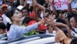 Burma's pro-democracy leader Aung San Suu Kyi touches the hands of her supporters as she arrives to attend the opening ceremony of her National League for Democracy (NLD) party's branch office in Yangon, May 23, 2012. 