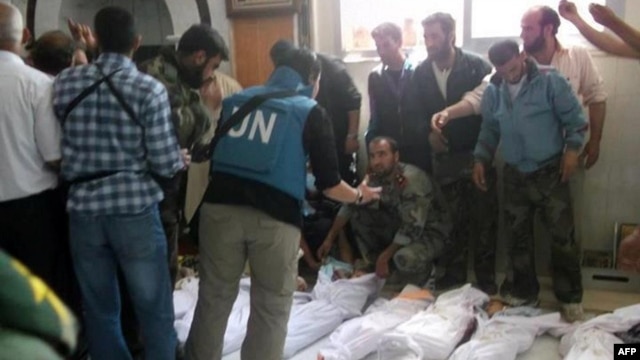Handout photo released by Syrian opposition's Shaam News Network shows UN observers at hospital morgue before their burial in central Syrian town of Houla