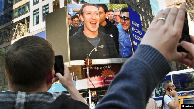En Nueva York los fanáticos de Facebook celebraron la aparición de Mark Zuckerberg en una de las pantallas gigantes de Times Square. [Foto: Reuters]